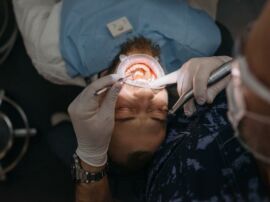 A person lying on an operating table having their wisdom teeth removed.